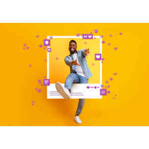 Bright smiling young man engaging with social media icons on vibrant yellow background, celebrating.