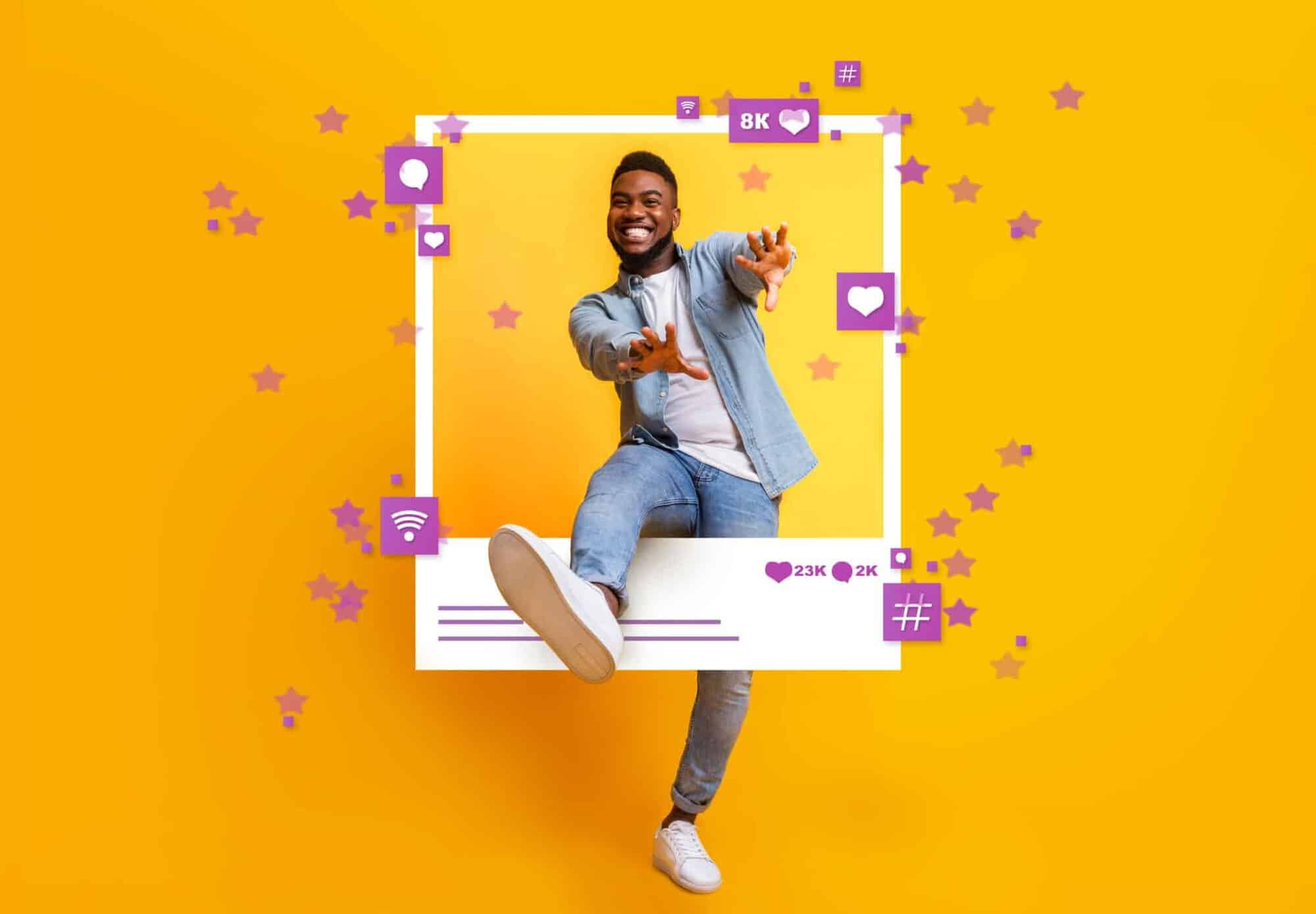 Bright smiling young man engaging with social media icons on vibrant yellow background, celebrating.