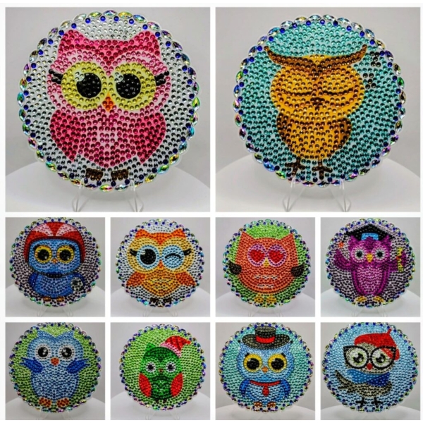Pink owl with large black eyes, decorated with colorful rhinestones, on a round white background.