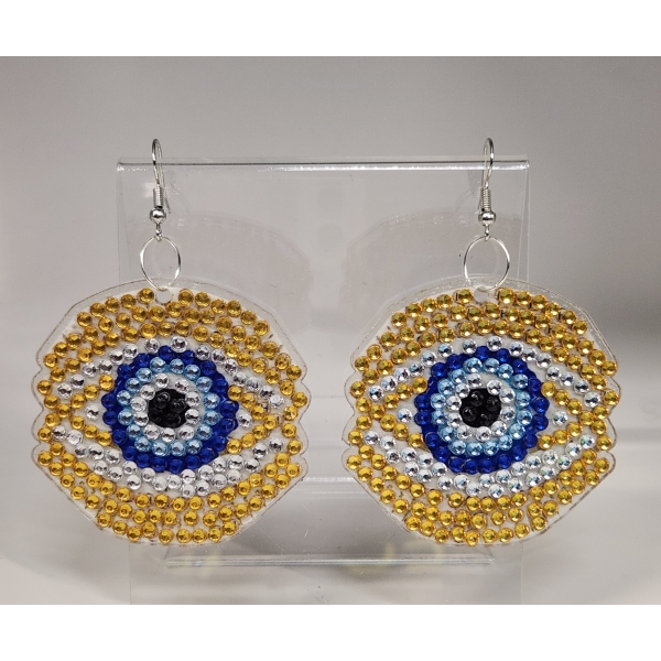 Golden and blue beaded eye-shaped earrings with silver hooks, displayed on a clear stand.