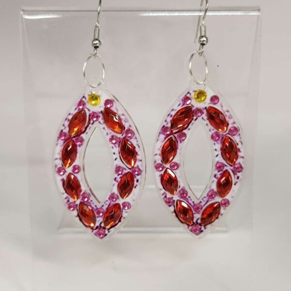 Stylish pink and red beaded earrings with oval-shaped gemstones and silver hooks.