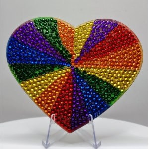 Colorful heart-shaped mosaic made of small, shiny beads in rainbow colors representing diversity and.