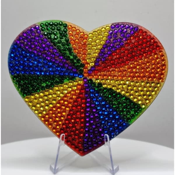 Colorful heart-shaped mosaic made of small, shiny beads in rainbow colors representing diversity and.