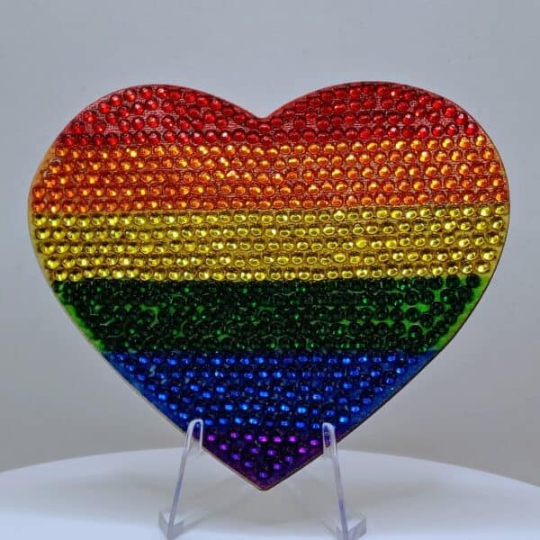 Rainbow heart-shaped jewelry piece with rainbow colors and rhinestone embellishments, symbolizing LG.