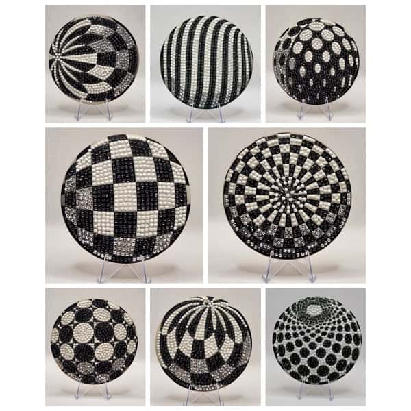 Vibrant black and white geometric patterned spherical sculptures for modern art display.