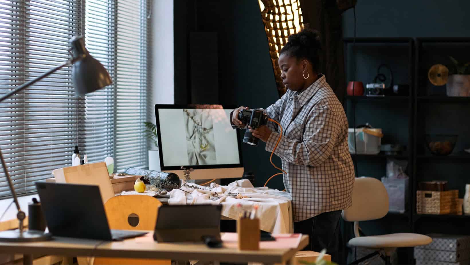 Black woman taking product photos in a studio for Black-owned businesses.