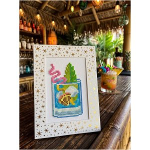 Cross-stitch art of a tropical drink with a pineapple and straw in a frame.