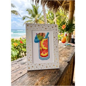 Colorful cross-stitch of a tropical drink with a straw and umbrella.