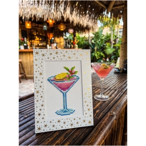 Colorful cross-stitch art of a cocktail glass with fruit and an umbrella.