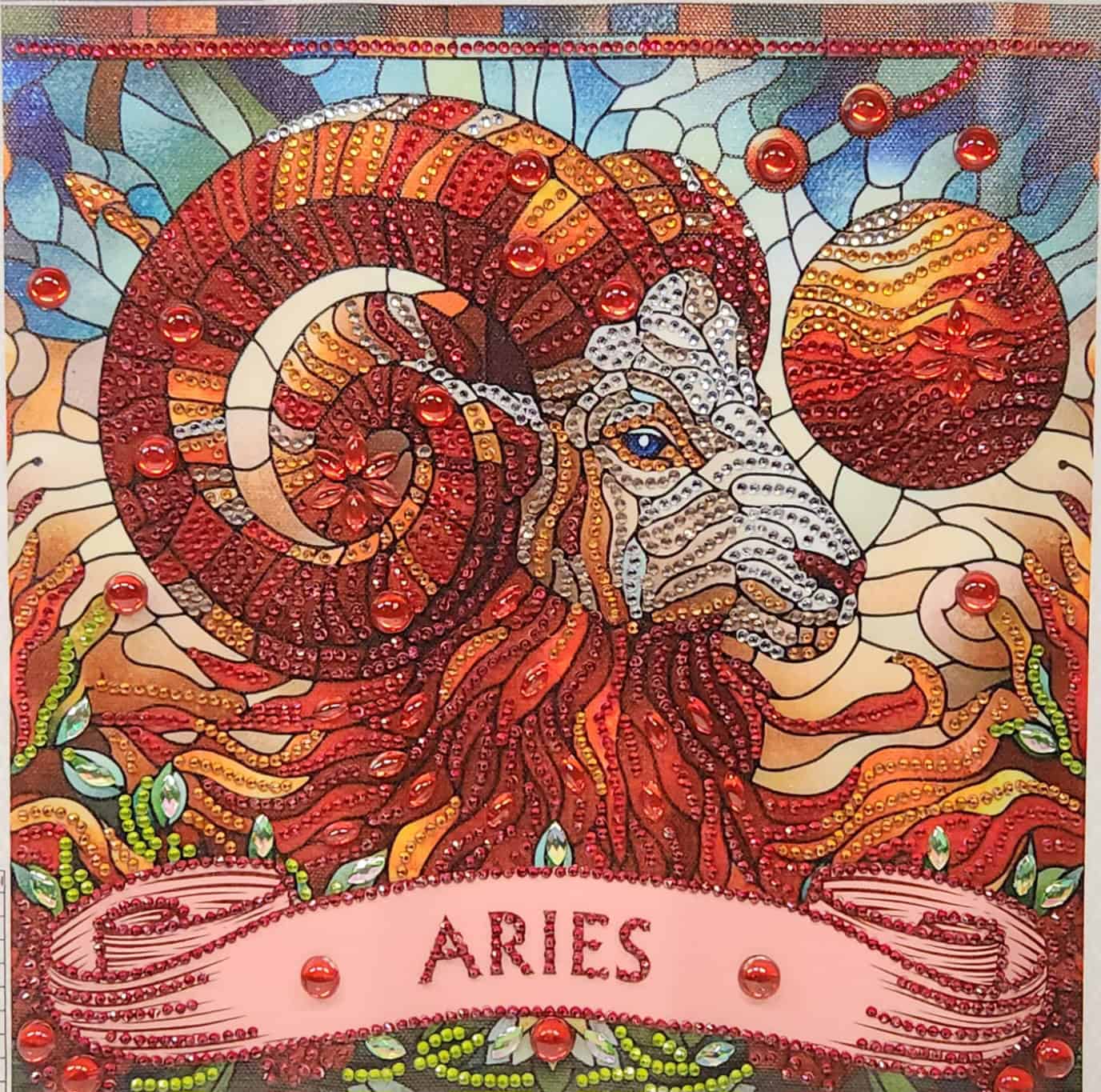 Aries zodiac illustration with a stylized ram head and vibrant mosaic patterns.